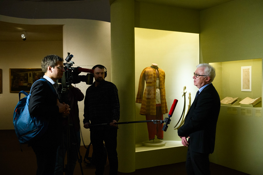 Директор государственного исторического музея А.К Левыкин дает интервью на фоне костюма казака-некрасовца из фондов РОМК